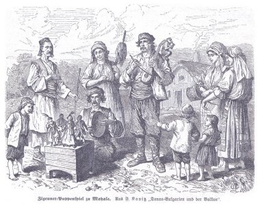 Müzisyenler, dansçılar ve ailelerle dolu canlı bir 19. yüzyıl köyü geleneksel elbiseler içinde ahşap bir kukla gösterisini izliyor, toplumsal neşe ve kültür mirasını yakalıyorlar..