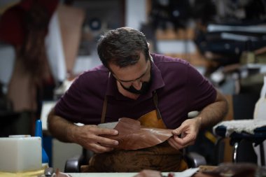 Yetenekli bir ayakkabı tamircisi, yoğun bir atölyede deri ayakkabı yapar, dikkatlice şekillendirir ve diker. Sahne, el aletleri ile geleneksel deri işçiliği, odaklanma ve adanmışlığı yakalıyor.