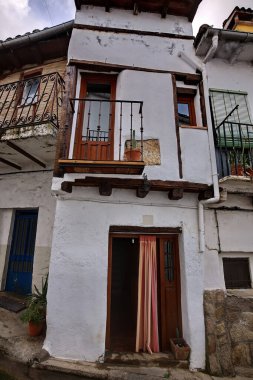 Küçük bir balkon, ahşap kapı ve saksı bitkilerinin yer aldığı büyüleyici, yıpranmış bir şehir merkezi. Tarihi karakteri ve samimi sokak manzarası olan kırsal bir mimari..