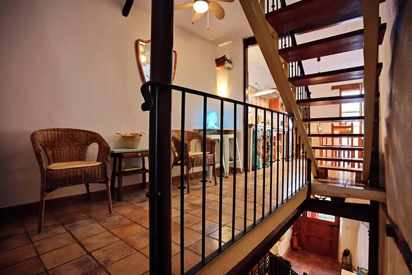 Sıcak, davetkar iç mekan hasır koltuklar fayanslı döşeme ve ahşap merdiven. Kafeler, dinlenme odaları ya da köy cazibesi ve ortam aydınlatması olan ev içleri için ideal rahat bir alan..