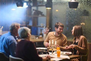 Aile üyeleri Ramazan için dekore edilmiş bir restoranda iftarın keyfini çıkarıyorlar. Yemeklerini, kahkahalarını ve anlarını sıcak bir ortamda paylaşırlar..