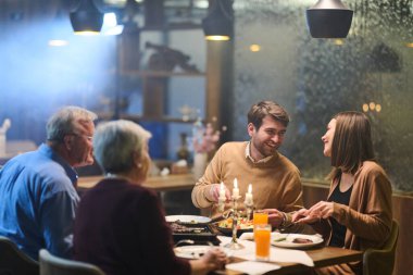 Müslüman aile, Ramazan ayında oruç tutmak için bir restoranda toplanıyor. Atmosferde, birlikteliği gösteren sıcak ışıklar ve geleneksel dekorasyonlar yer alıyor..