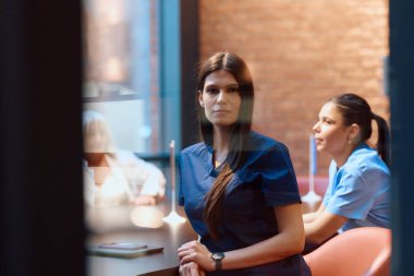 İki sağlık çalışanı modern bir klinikte sohbet ediyorlar..