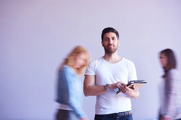 Estudiante trabajando en la tableta, grupo de personas que pasa por — Foto de Stock