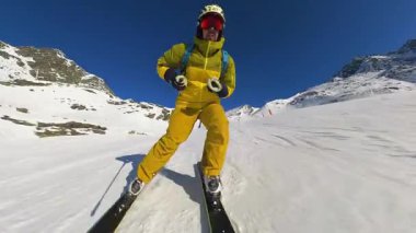 Solo kayakçının heyecanını hissedin. Temiz mavi bir kış gökyüzü altında, soluk kesici dağ manzaralarıyla çevrili el değmemiş, karla kaplı bir dağda taze izler kazıyor..