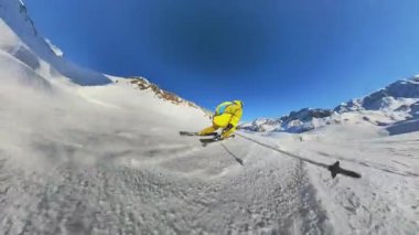 Keyifli bir kayak deneyimini birinci şahıs bakış açısından yaşayın. Yalnız bir kayakçı el değmemiş karla kaplı bir dağa döner, parlak güneş ışığı ve açık mavi gökyüzünün tadını çıkarır. Kış için mükemmel.