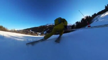 Parlak, güneşli bir kış gününde el değmemiş bir dağ yamacında kayak yapmanın coşkusunu yaşayın. Birinci şahıs perspektifi, büyüleyici karlarla çevrili dinamik hareketi yakalar.