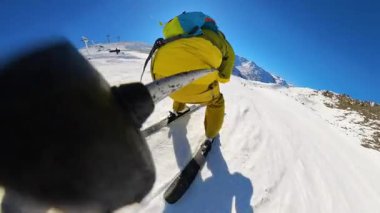 Parlak, güneşli bir kış gününde el değmemiş bir dağ yamacında kayak yapmanın coşkusunu yaşayın. Birinci şahıs perspektifi, dinamik dönüşleri ve karla kaplı dorukları yakalar..