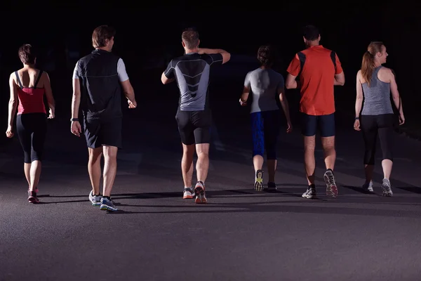 Folk grupp jogging på natten — Stockfoto