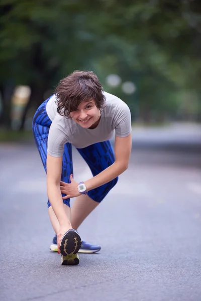 Vrouw die zich uitstrekt voordat ochtend joggen — Stockfoto