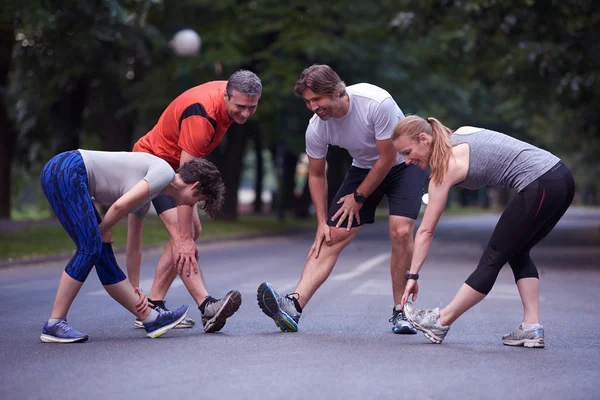 トレーニング前に公園でストレッチするジョギンググループ — ストック写真