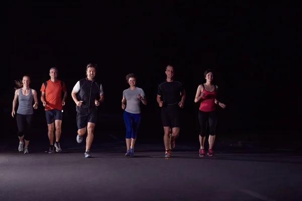 Persone gruppo jogging di notte — Foto Stock