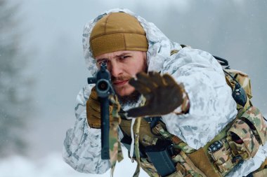 Beyaz kış kamuflajlı bir asker, soğuk hava taktik eğitimi sırasında ya da karlı bir orman ortamında askeri devriye sırasında, kar yağan kar ortasında, odaklanmış ve tetikte bir tüfeği hedefler..