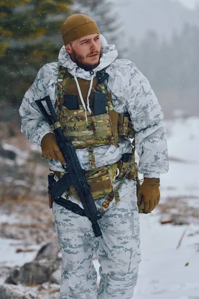 Beyaz kış kamuflajı ve taktik yelek giyen bir asker, karlı bir ormanda devriye gezerken bir tüfek taşıyor, hazırlık, dayanıklılık, soğuk hava operasyonları ve ağır askeri eğitimler yapıyor.