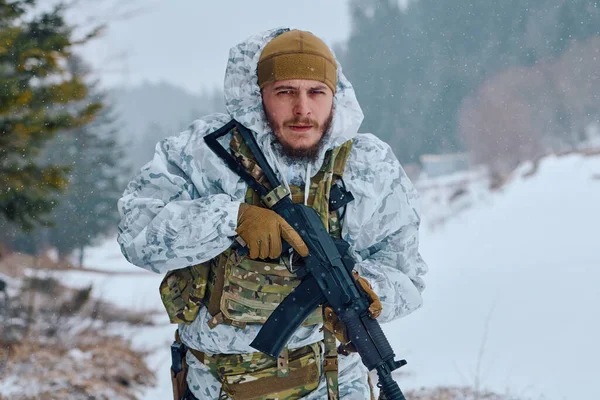 Beyaz kış kamuflajı ve taktik teçhizatı takan bir asker, karlı bir ormanda devriye gezerken bir saldırı tüfeği tutuyor ve hazırlık, dayanıklılık ve soğuk hava askeri operasyonlarını sürdürüyor..