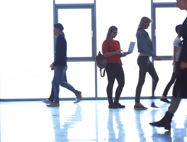 Étudiante fille debout avec ordinateur portable, groupe de personnes passant par — Photo