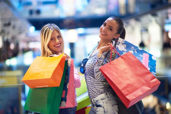 Happy young girls in shopping mall — Stock Photo, Image