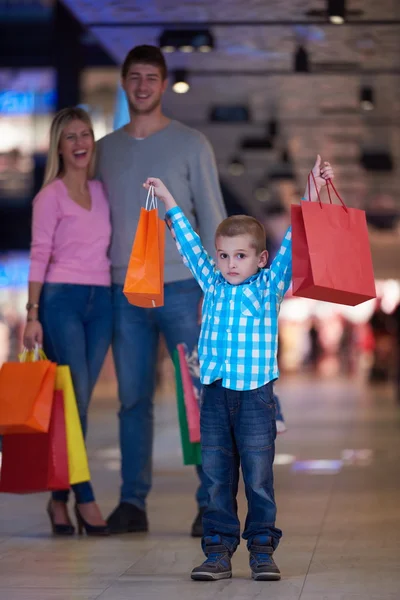 Ung familj med kassar och påsar — Stockfoto