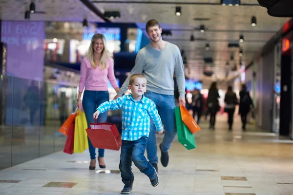 Ung familj med kassar och påsar — Stockfoto