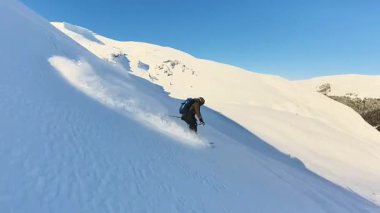 Keyifli bir helezon kayağı macerası sırasında el değmemiş bir dağdan derin bir tozla inen yaşlı bir kayakçının heyecanını yaşayın. Aktif yaşam tarzı ve kış sporu temaları için mükemmel.