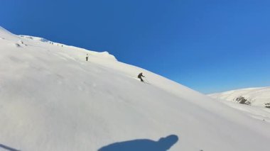 Kıdemli dostların el değmemiş, karla kaplı bir dağda helikopter kayağı yapmalarının neşesini yaşayın. Parlak, mavi gökyüzü gününde taze, derin bir tozda serbest kayak macerasının tadını çıkar..