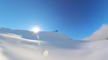 Kıdemli arkadaşlar, el değmemiş derin toz kar ve parlak mavi gökyüzü altında nefes kesen dağ manzaralarıyla çevrili heyecan verici bir helikopter kayağı macerasına hazırlanıyorlar..