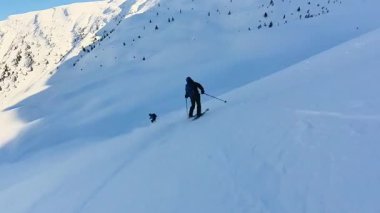 Arkadaşlar, el değmemiş derin toz karını, nefes kesen bir dağ macerasında, helezonik kayağı yapmanın coşkusunu yaşıyorlar. Uçsuz bucaksız, el değmemiş yamaçların tadını çıkarıyorum.