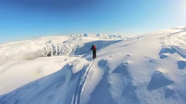 Yaşlı arkadaşlar heyecan verici bir helikopter turuna çıkıyorlar, engin, güneşli dağ yamaçlarında taze, derin kar parçalarını oyuyorlar. Disk dışı serbest kayak yapmanın heyecanını yaşayın.