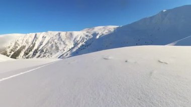 Serbest gezen bir kayakçının el değmemiş, karla kaplı bir dağdan kayak pisti kazımasının heyecanını yaşayın. Derin kar ve engin kış manzarasının el değmemiş güzelliğinin tadını çıkar..