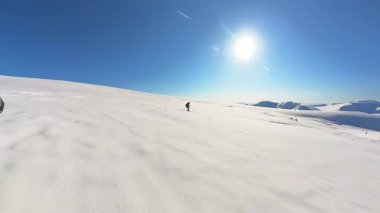 Kıdemli arkadaşlar, heyecan verici bir helikopter turunun tadını çıkarıyorlar. Parlak mavi gökyüzü altında, taze, derin toz kar altında kayak yapmanın heyecanını yaşıyorlar..