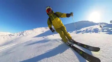 Experience the thrill of active senior friends heliskiing and freeride skiing down untouched deep powder slopes. Enjoy the crisp winter air and stunning mountain views under a radiant blue sky.