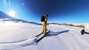 Saf dağ yamaçlarında kayak yapmanın heyecanını yaşayın. Açık mavi gökyüzünün altında taze toz karla kaplı..