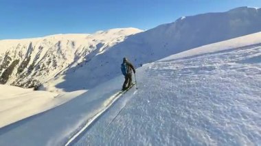 Neşeli bir helikopter kayağı turunda olan bir grup kıdemli arkadaş, güneşli bir dağda el değmemiş, taze, derin bir toz karının içinden dönüyorlar. Kış sporları için unutulmaz bir serbest macera.