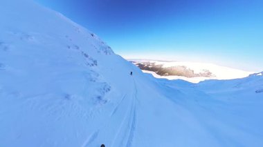Serbest bir turda pistte helikopter kayağı yapmanın heyecanını yaşayın. Kıdemli arkadaşlar, berrak mavi gökyüzünün altında sersemletici bir dağ manzarasında kışı kucaklayan taze toz karını oyup çıkarırlar.