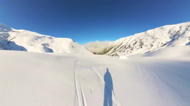 Kıdemli arkadaşlarla serbest hava kayağı yapmanın heyecanını yaşayın. Parlak bir günde, taze toz karla kaplı, görkemli kış dağlarıyla çevrili el değmemiş yamaçları keşfetmek..