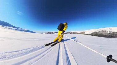 Yalnız bir maceracının el değmemiş bir dağ manzarasında taze kar kazıyarak kayak yapmanın heyecanını yaşayın. Açık mavi gökyüzü altındaki nefes kesen manzaranın tadını çıkar, özgürlüğünü kucaklayan