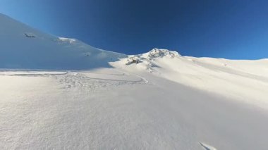 Arkadaşlar heyecan verici bir helikopter kayağı ve serbest kayak turuna çıkıyorlar. Temiz mavi gökyüzünün altındaki el değmemiş dağlarda taze, derin toz karları oyup maceraya atılırlar.