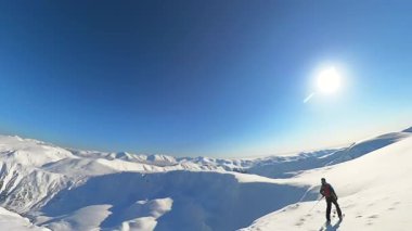 Nihai helezonik kayak macerasını deneyimleyin, açık mavi gökyüzü altında sersemletici bir kış dağ manzarasında, derin, taze toz karda serbest kayak yapmak. Heyecan verici bir açık hava sporu.