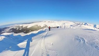 Yetenekli bir serbest kayakçı el değmemiş derin toz karları oyup parlak mavi gökyüzünün altında görkemli bir dağ zirvesine iniyor. Uçsuz bucaksız bir kış harikalar diyarında kayak yapmanın heyecanını yaşayın.