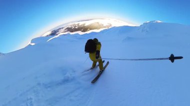 A senior adventurer embarks on an exhilarating heliskiing tour, gliding through fresh, deep powder snow on a pristine mountain slope. This off-piste freeride experience offers unparalleled freedom and