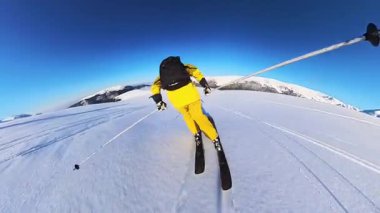 Capture the exhilaration of a backcountry ski tour, as a lone skier carves fresh tracks through pristine, deep powder snow on a vast mountain, bathed in bright sunshine.