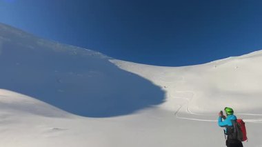Kıdemli arkadaşlar, heybetli bir dağda, el değmemiş derin toz karların arasından raylar kazıyarak, heyecan verici bir helezon kayağı ve serbest kayak macerasının tadını çıkarıyorlar. Onların piste çıkmayan turları paylaşılan mutluluğun altını çiziyor