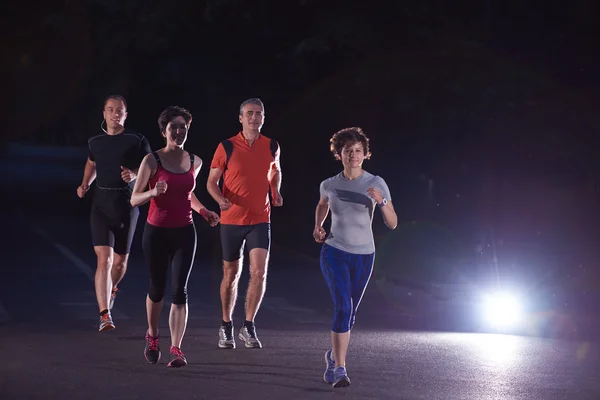 Persone gruppo jogging di notte — Foto Stock