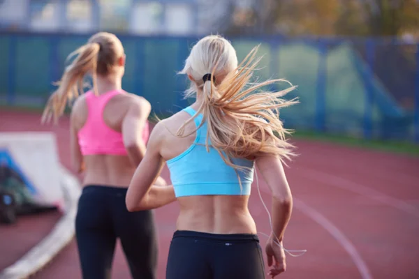 Athlète femme groupe courir sur piste de course d'athlétisme — Photo