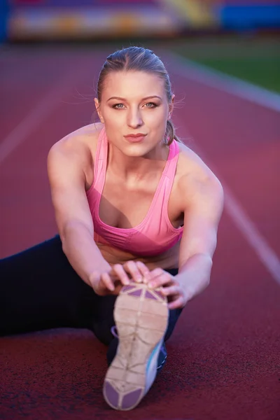 Mulher esportiva na pista de corrida atlética — Fotografia de Stock