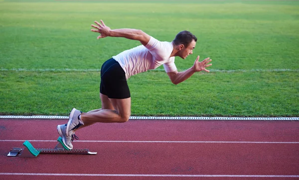 Atletische man start op de rails — Stockfoto