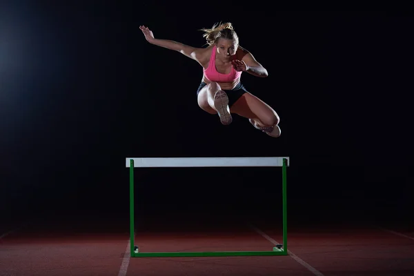 Woman athlete and hurdles — Stock Photo, Image