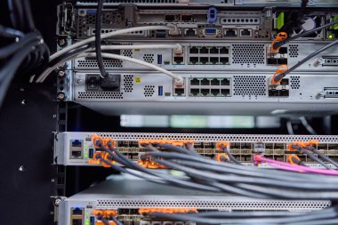 Bağlantı noktalarına bağlı anahtarlar, fiber optik ve ethernet kabloları, bağlantı, bilişim altyapısı, yüksek performanslı ağ ekipmanları ve telekom kablosu bulunan bir ağ sunucusunun yakın plan görüntüsü