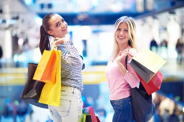 Happy young girls in shopping mall — Stock Photo, Image