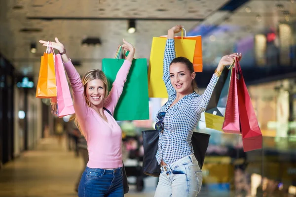 Happy young girls in shopping mall — Stock Photo, Image